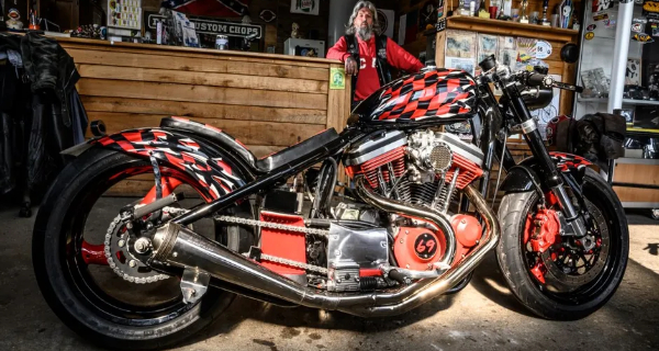 une moto rouge et noir ainsi que le garagiste